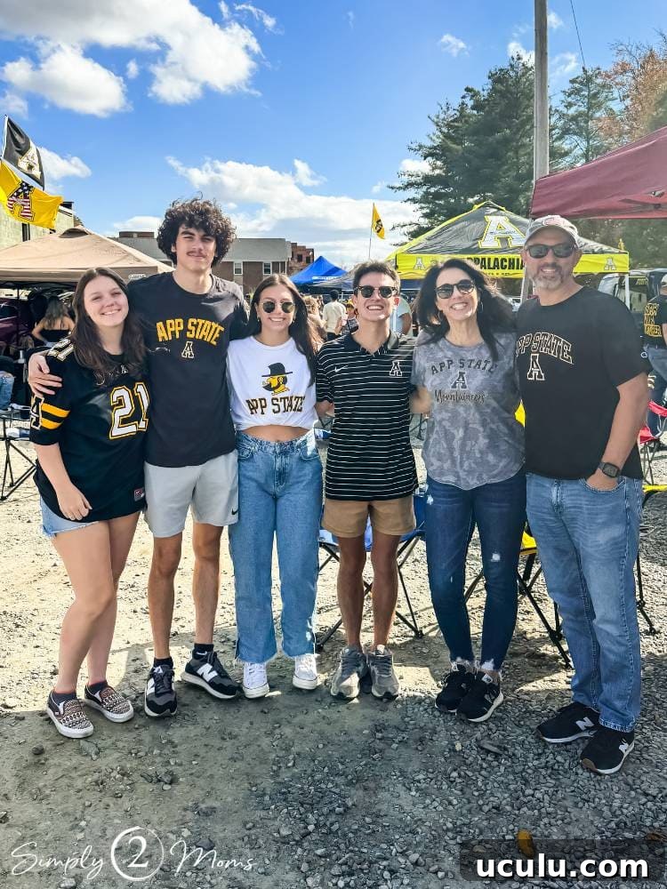 group of people standing together at college football game tailgate party