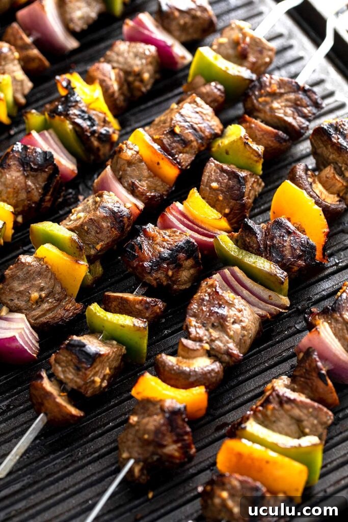 Steak and vegetables on skewers over a hot grill