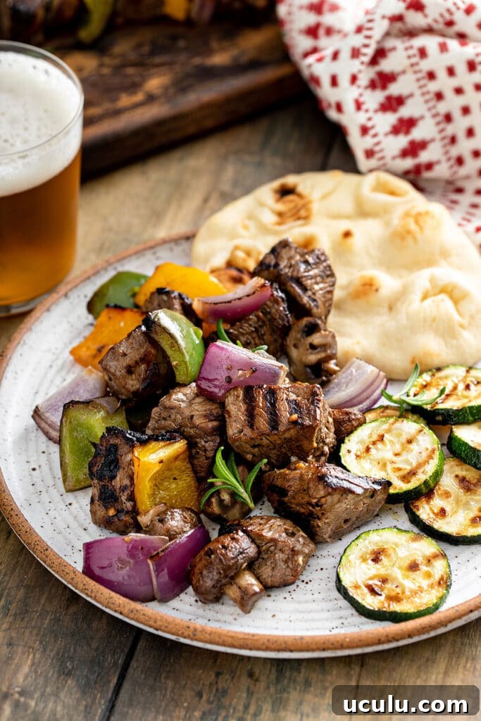 Grilled steak tips and veggies served on. plate with pita bread