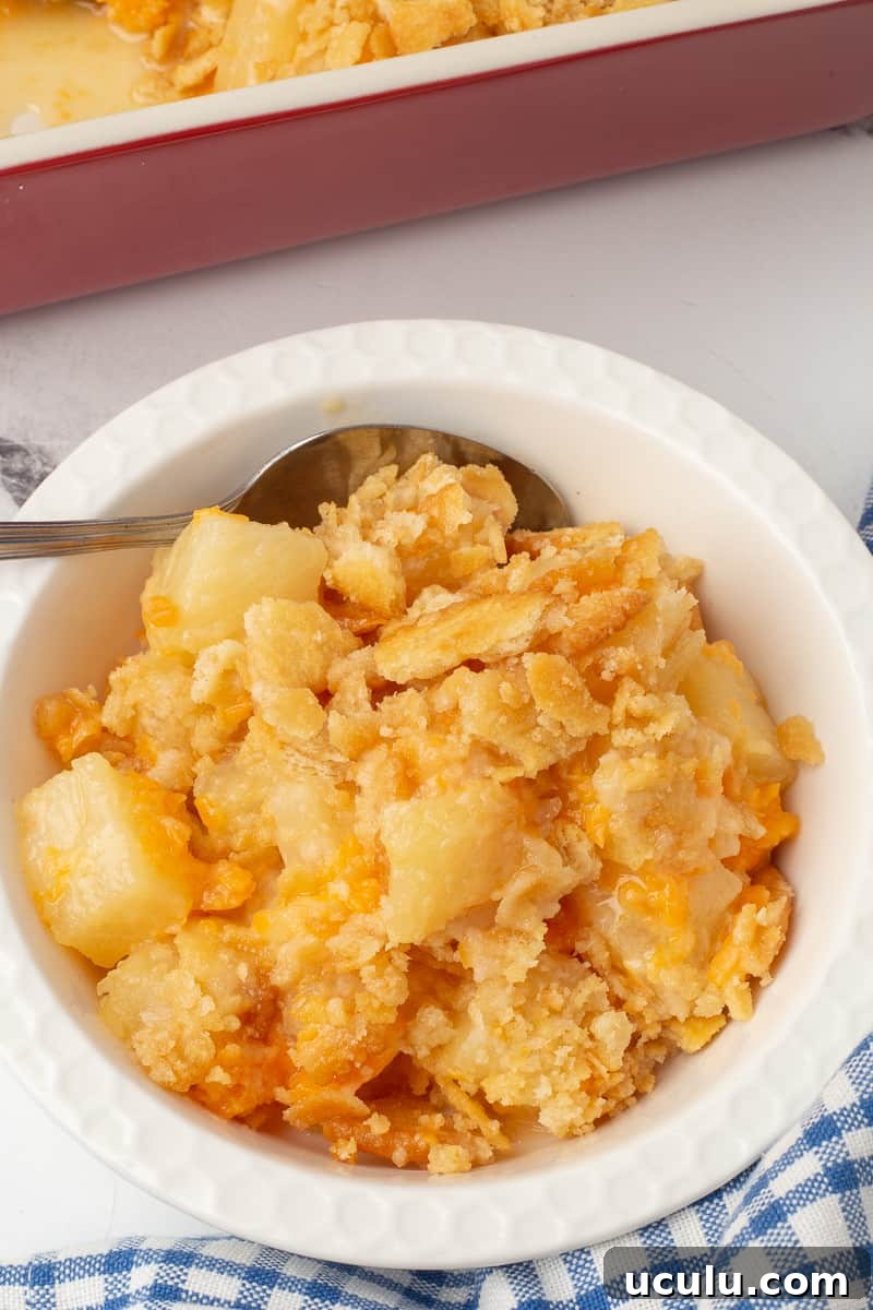 Pineapple ritz casserole in a white dish with a spoon.