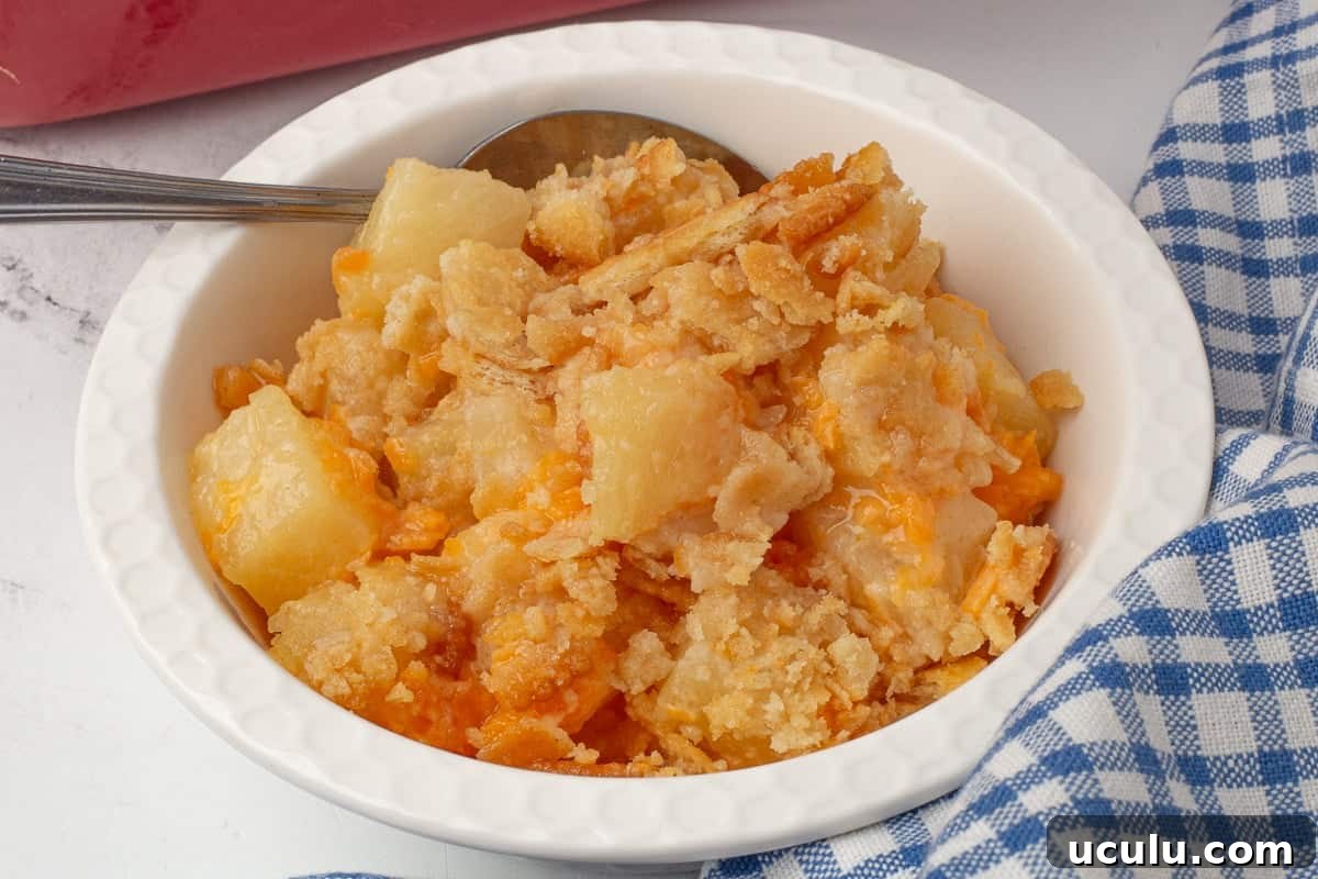 Pineapple casseole in a white bowl with a spoon.