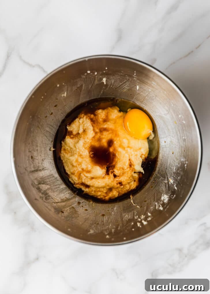 A silver bowl of butter, sugar, eggs, and vanilla.
