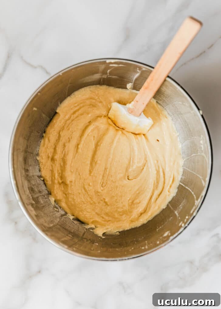 A silver bowl of batter for high altitude yellow cupcakes.