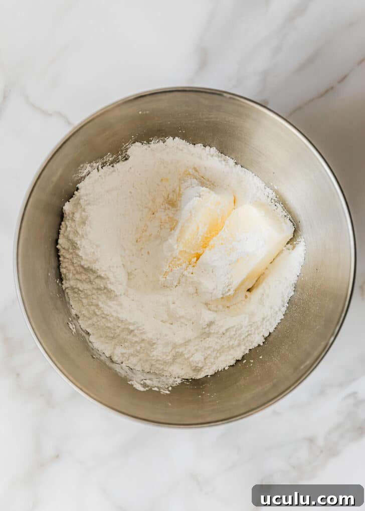 A silver bowl of butter and powdered sugar on a white counter.