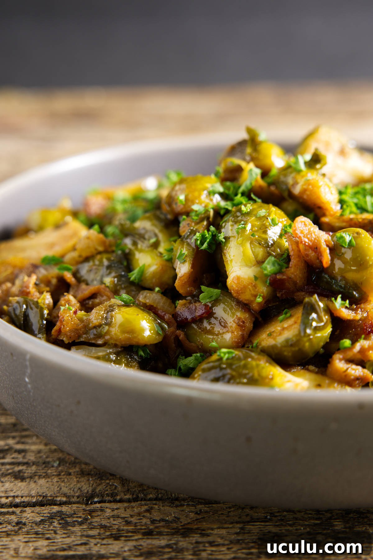 smoked brussels sprouts served in a bowl with a drizzle of hot honey on top