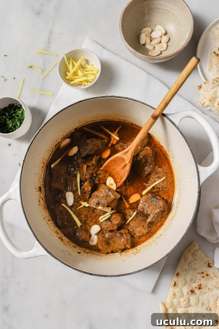 Mutton/Lamb Korma in a pot garnished with almonds and julienned ginger.