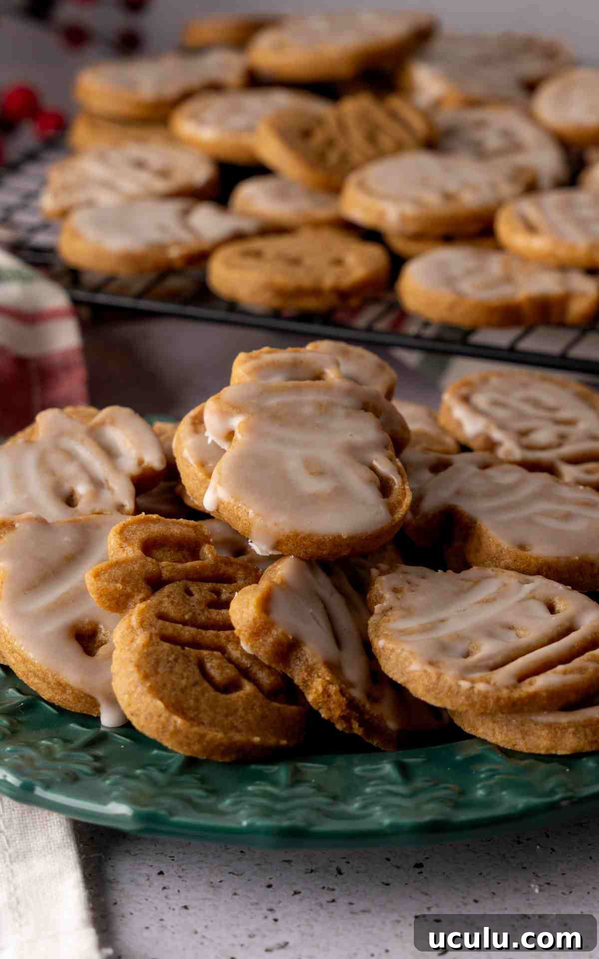 A green plate with snowman and bulb shaped molasses cookies.