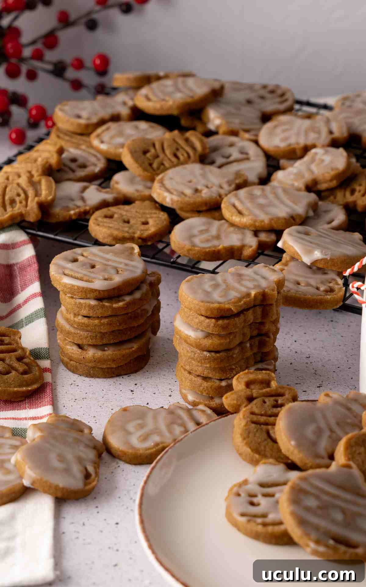 Stacks of molasses cut out cookies with vanilla glaze.