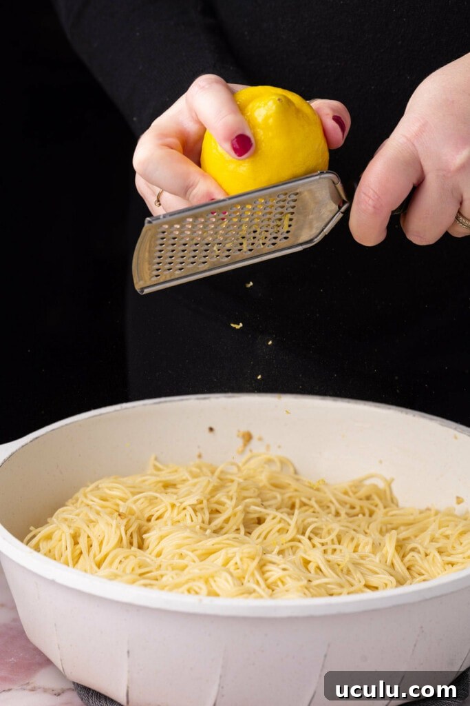 Zesting a lemon over a pan of pasta. 