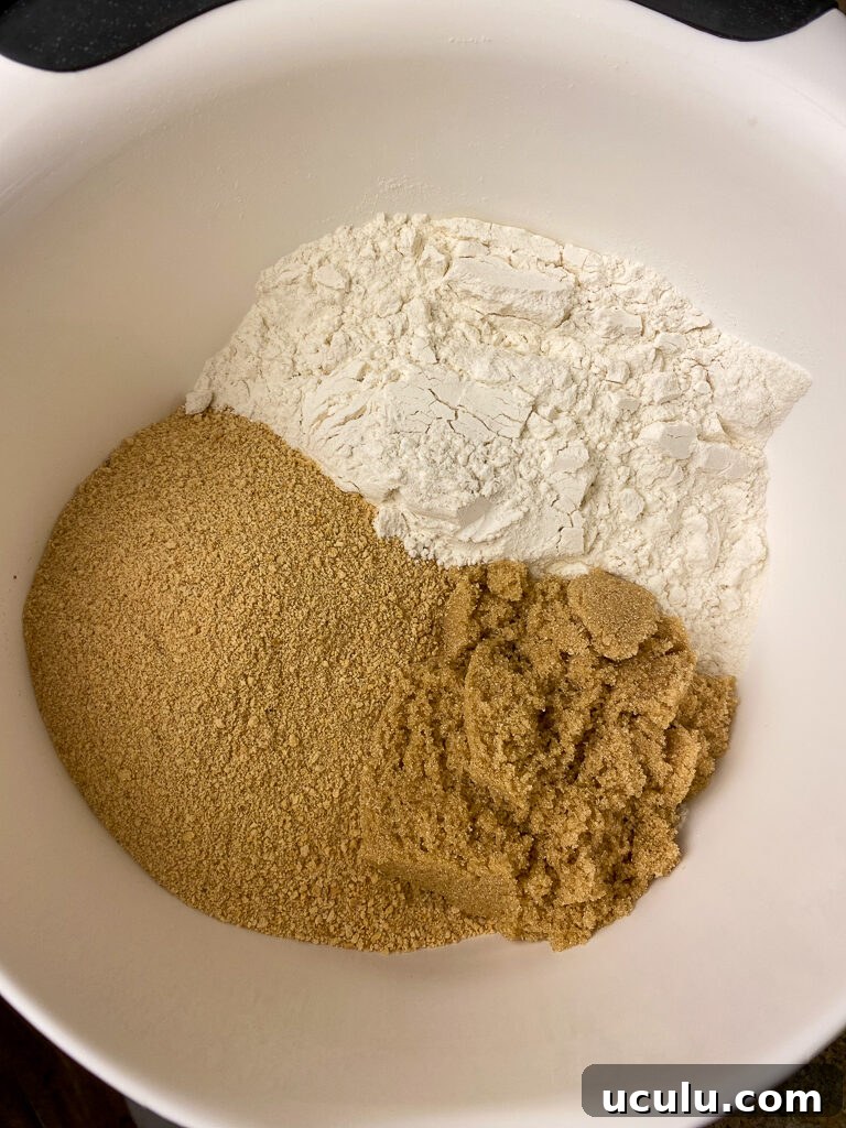 Flour, brown sugar and graham cracker crumbs in a medium white mixing bowl