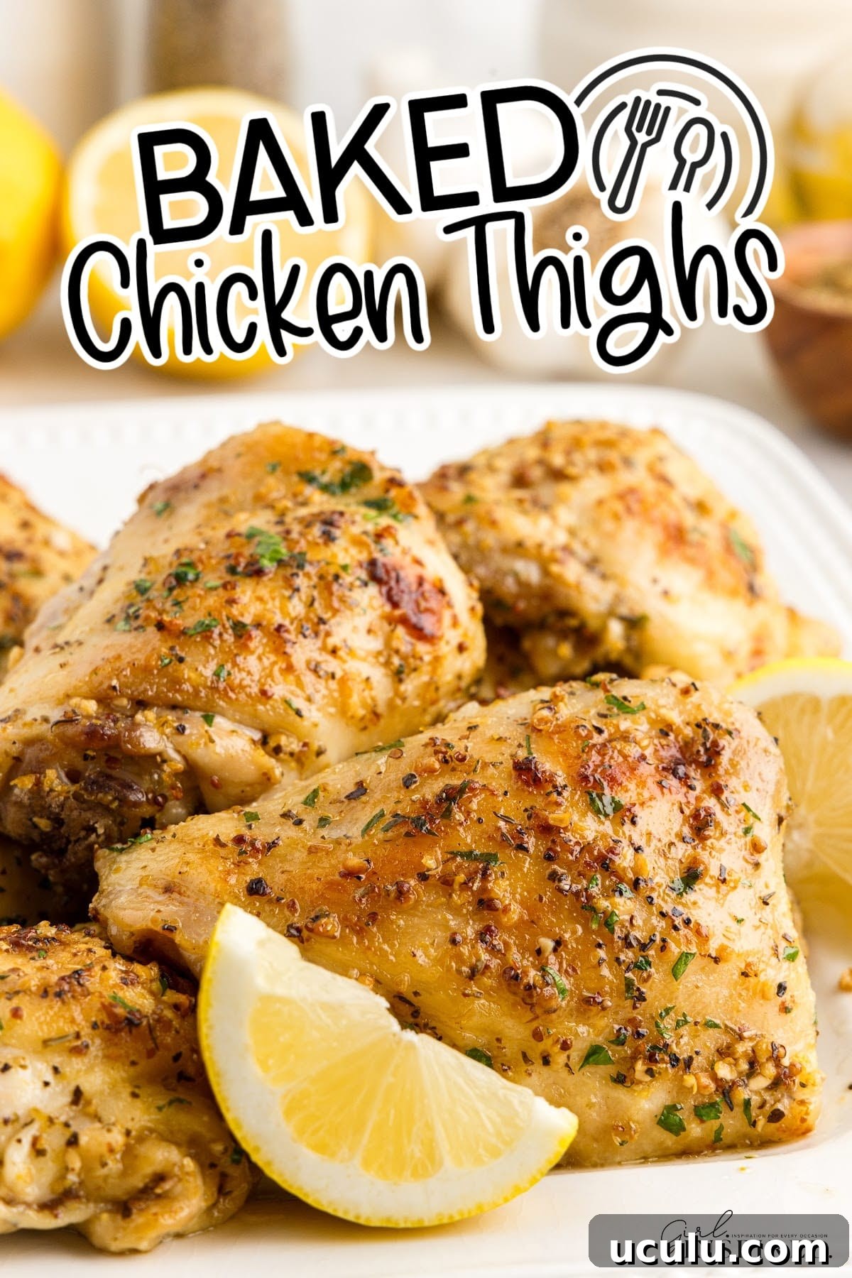 Baked Chicken Thighs on a platter with lemon slices with text overlay.