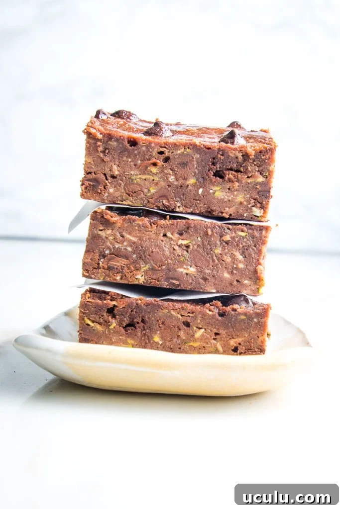 A stack of chocolate zucchini brownies with chocolate chips
