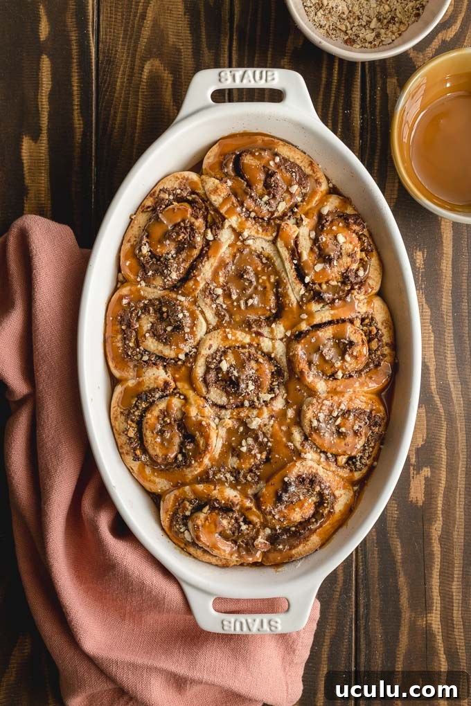 Overhead view of Nutella rolls baked up in a white dish and topped with dulce de leche.