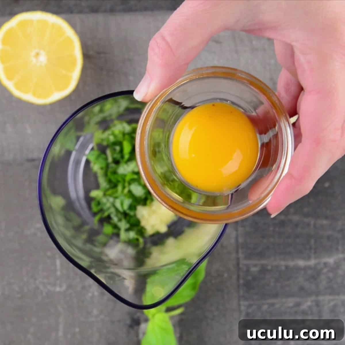 adding egg yolk to make basil garlic aioli.