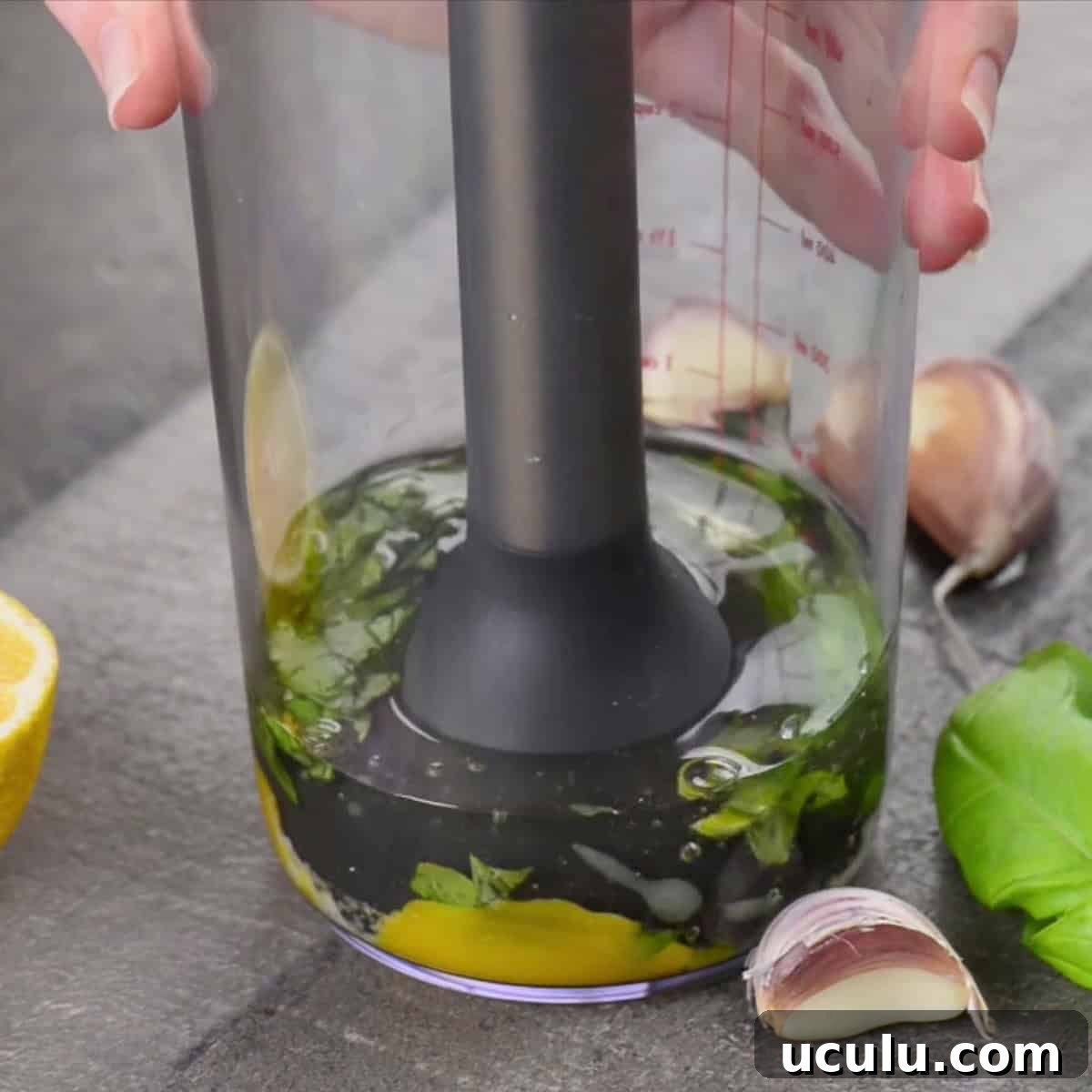 using immersion blender to make basil garlic aioli.