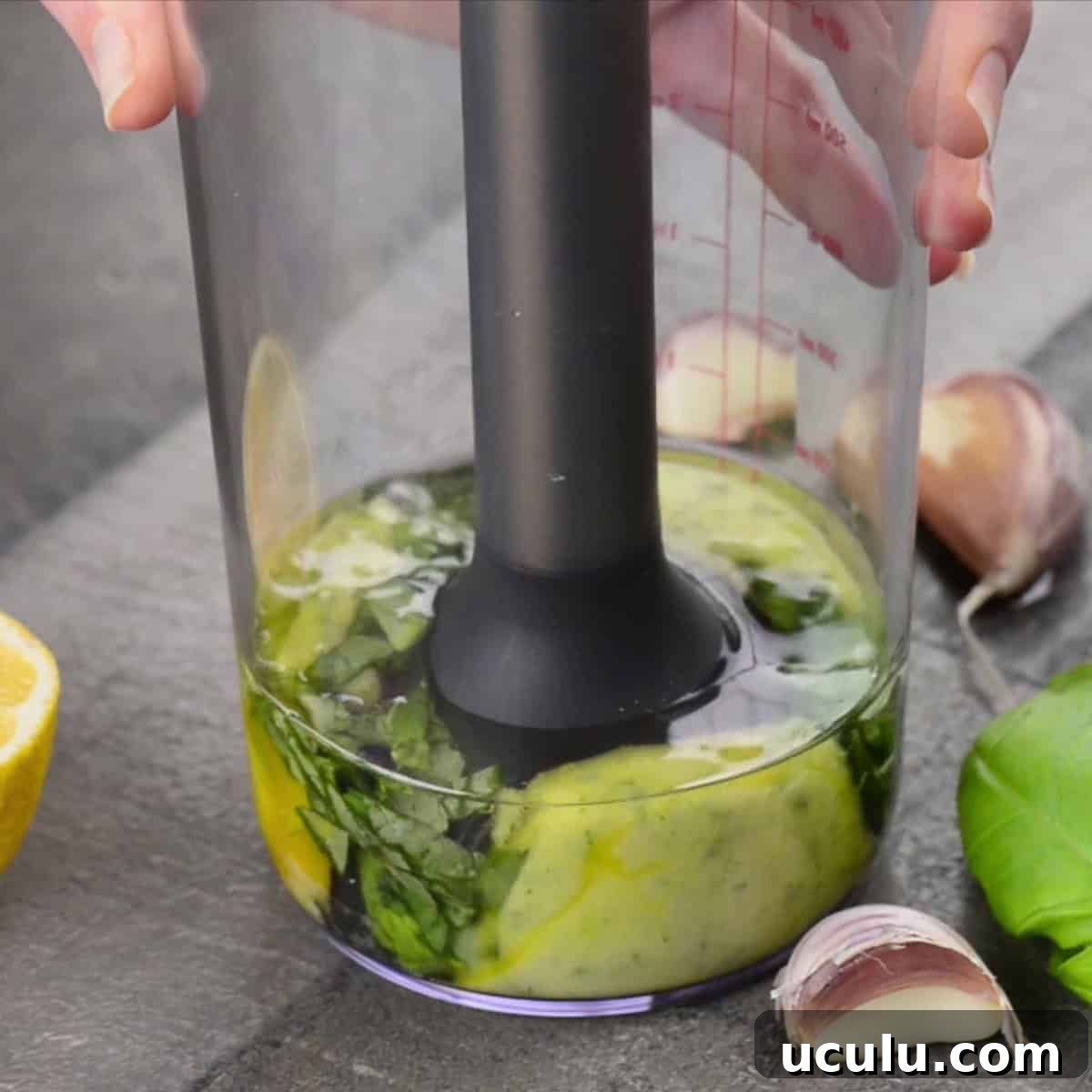 using immersion blender to make basil garlic aioli.