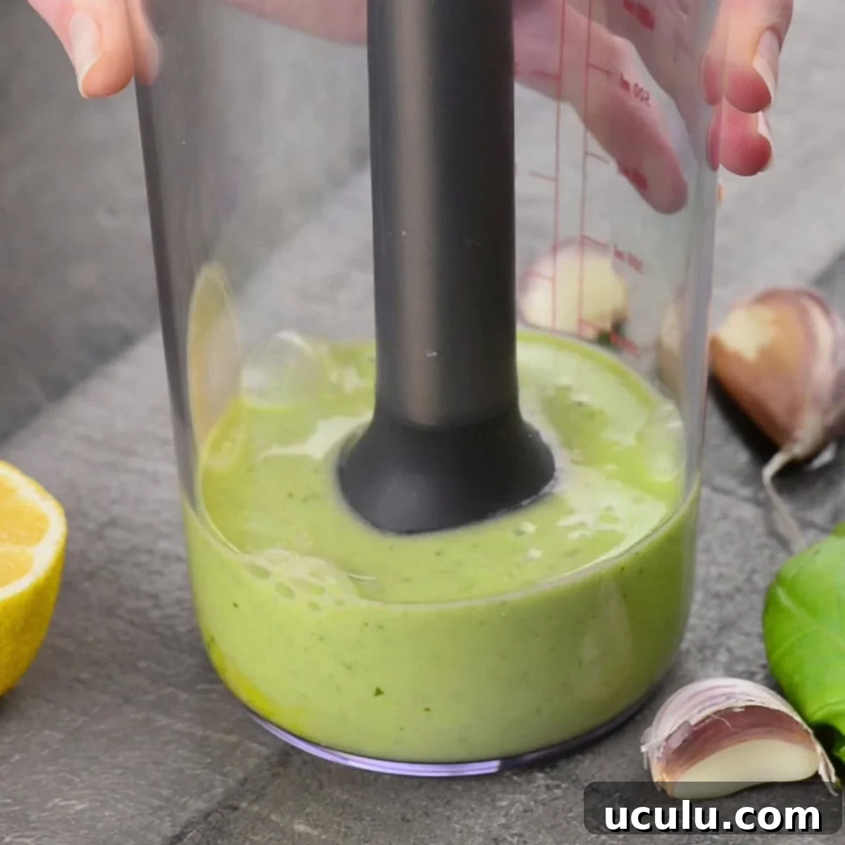 using immersion blender to make basil garlic aioli.