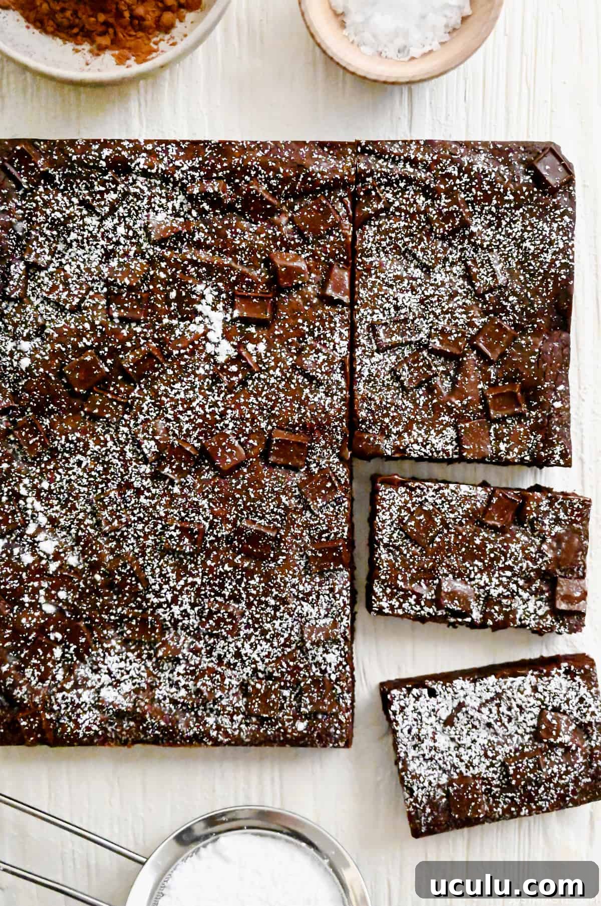 Homemade brownies studded with chocolate chunks dusted with powdered sugar.
