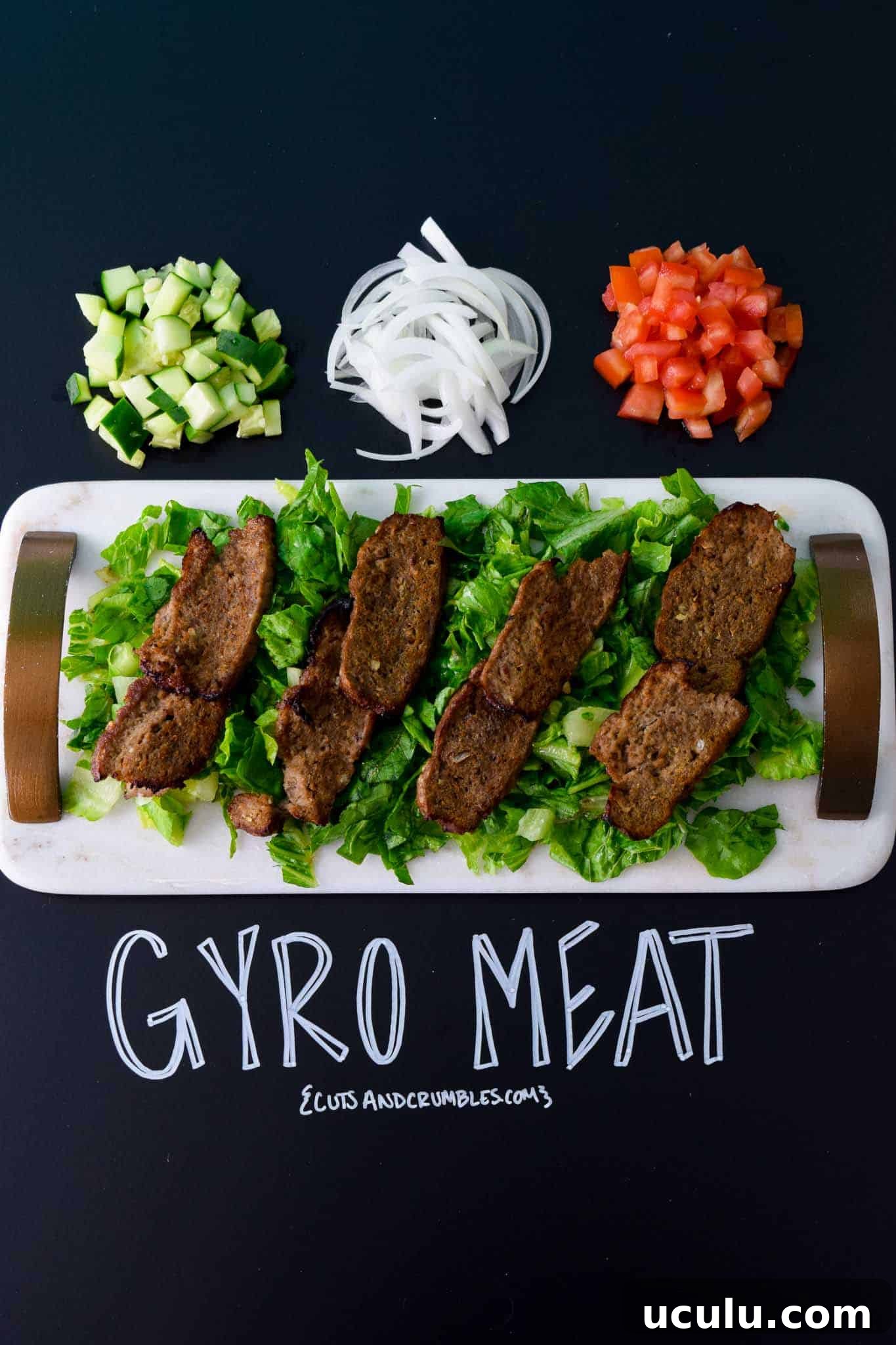 Gyro Meat on white platter with title written on chalkboard 