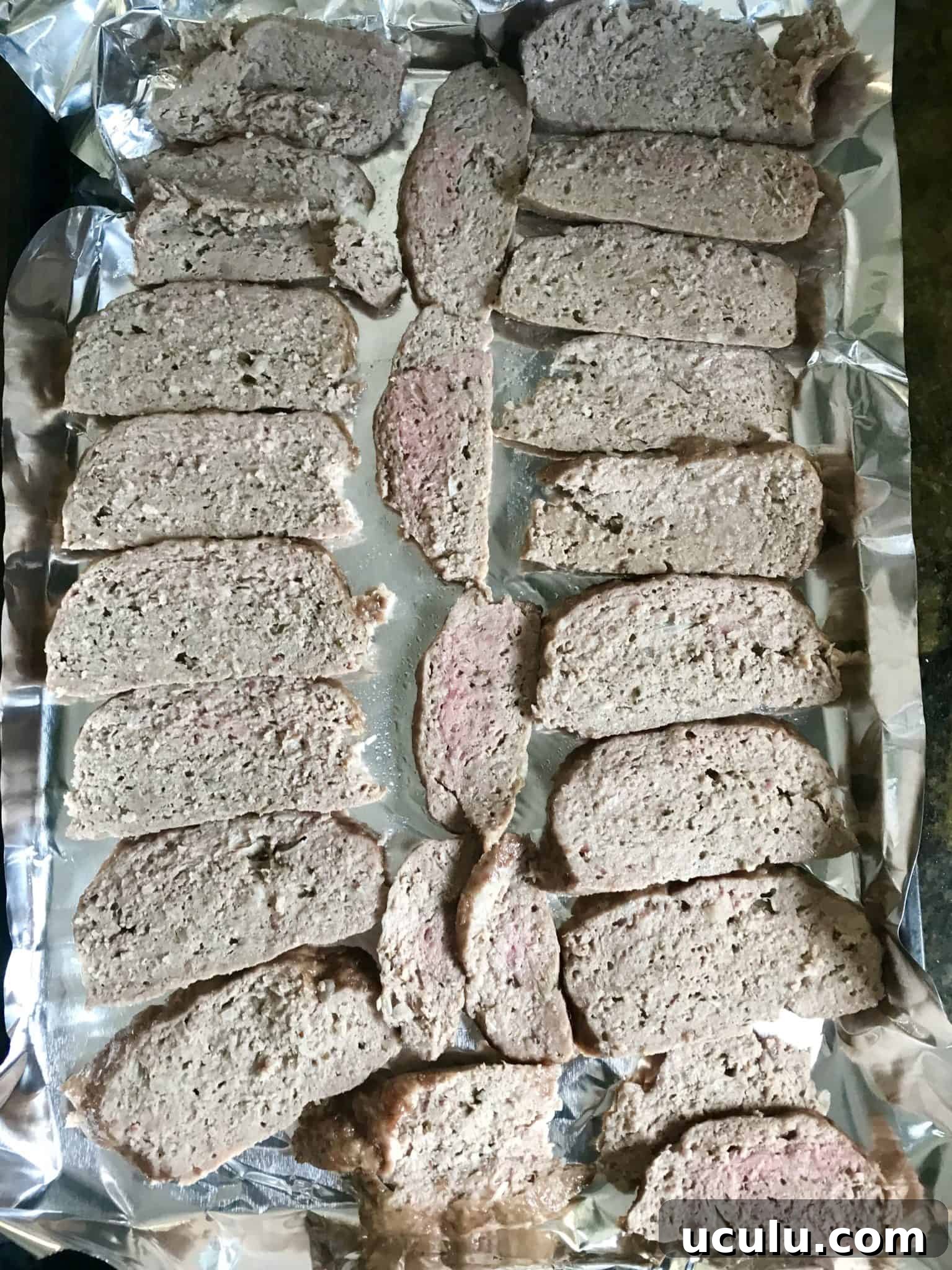 Gyro Meat sliced on baking sheet reading to be cooked