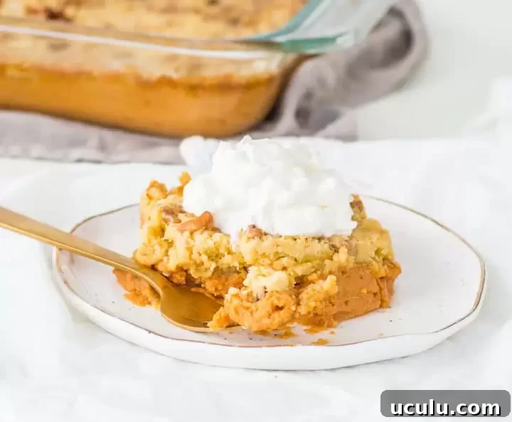slice of pumpkin pie cake on a plate with a fork taking a bite out of it