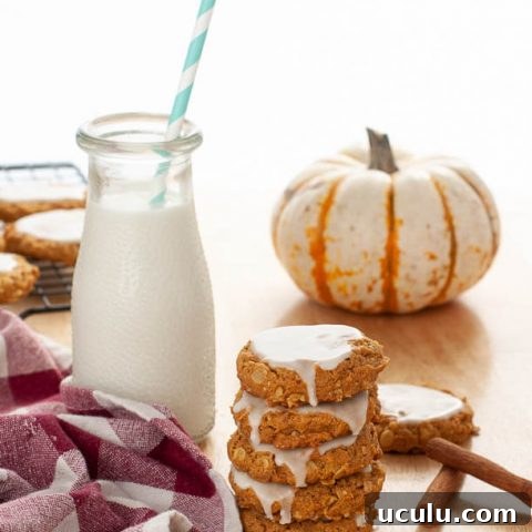 gluten-free-dairy-free-iced-pumpkin-oatmeal-cookies-stacked-by-milk-and-a-mini-pumpkin