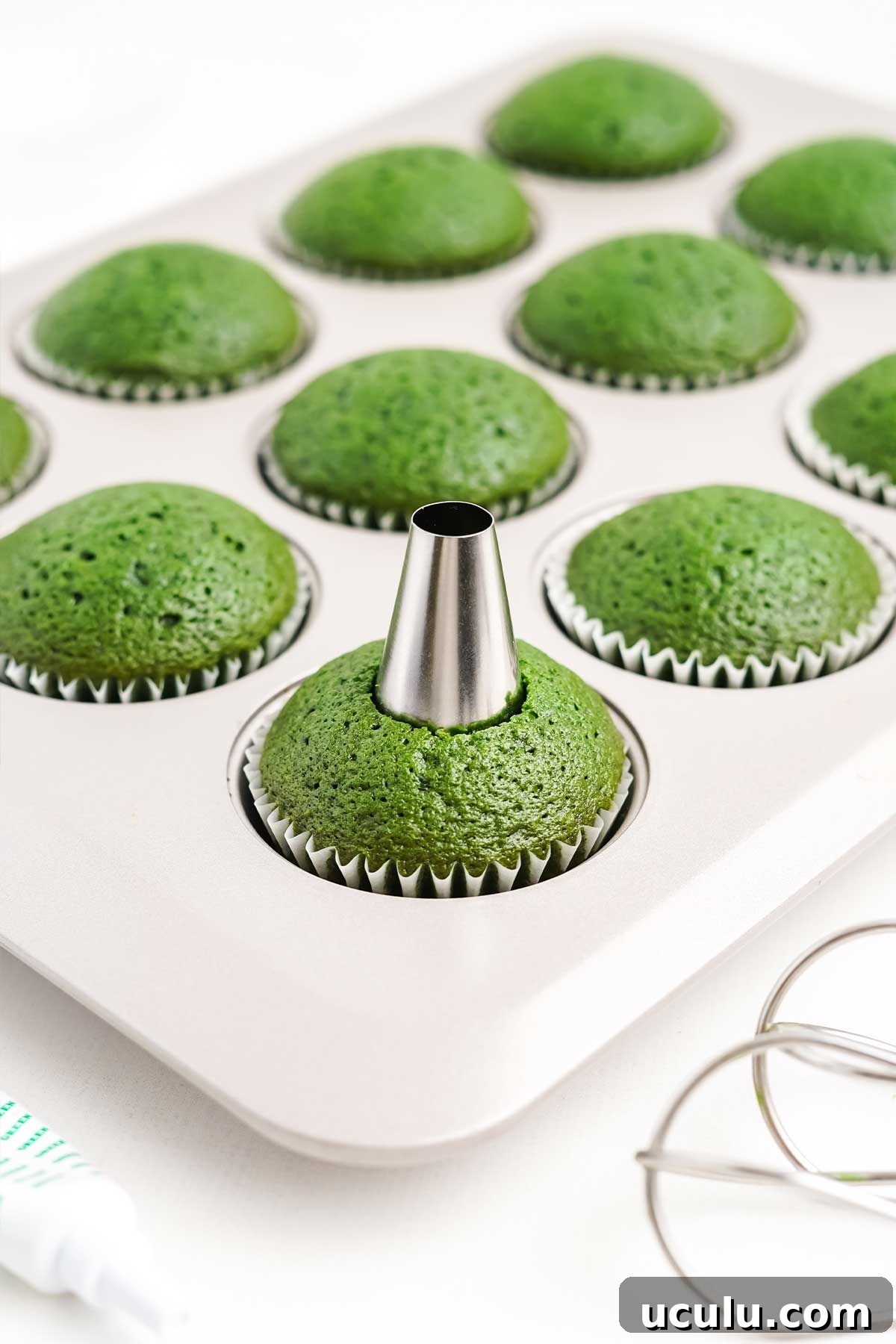 Poking a hole in the cupcakes.