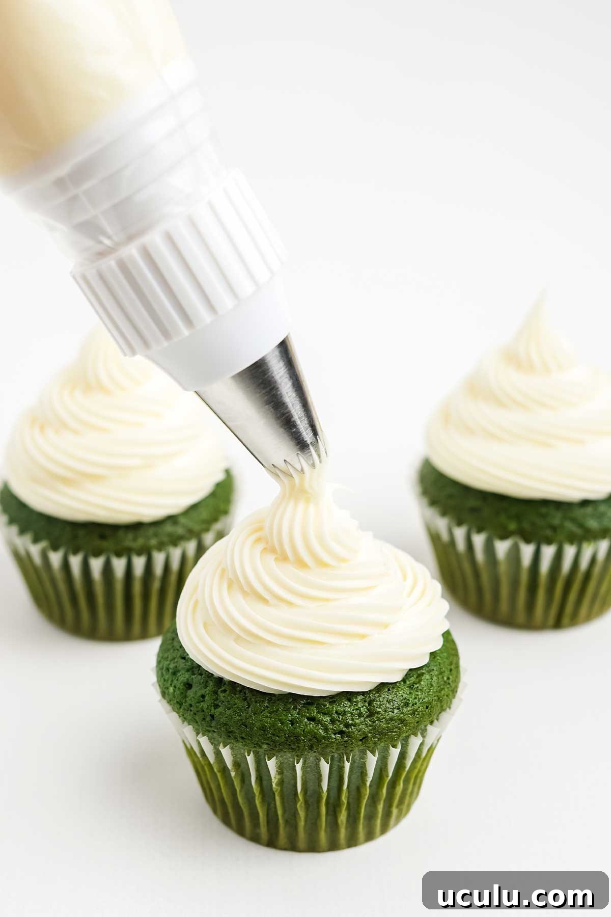 Piping the frosting on the top of the cupcakes.