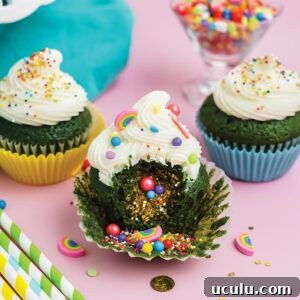 St Patrick's Day cupcakes missing a bite to show sprinkles spilling out of inside.