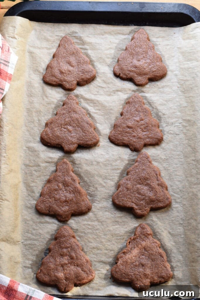 Baked Christmas tree shortbread on a baking tray.