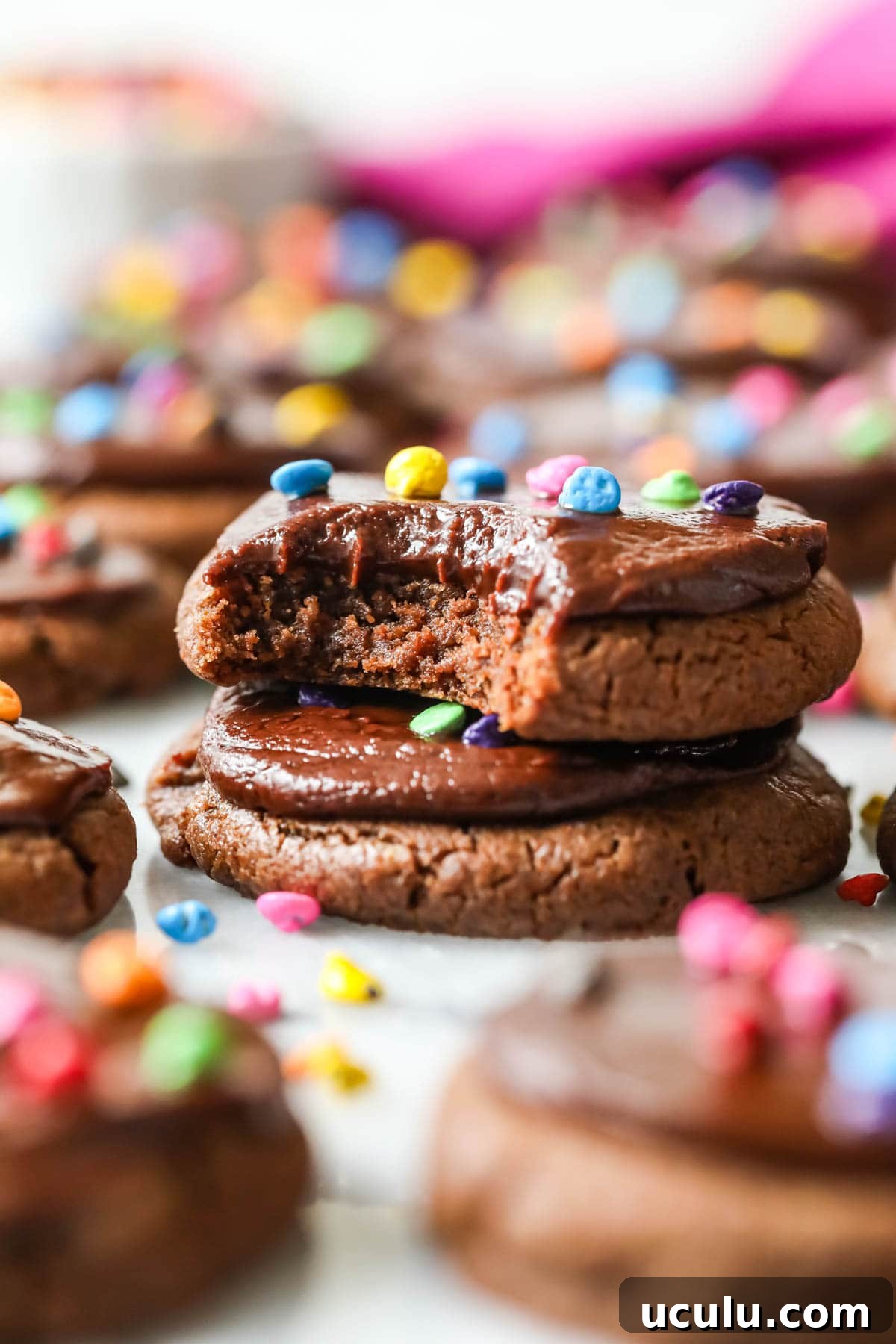 Two cosmic cookies stacked on top of each other with the top cookie missing a bite.
