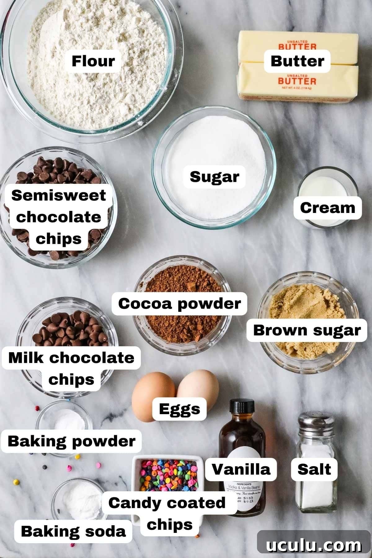 Overhead view of labelled ingredients including cocoa powder, chocolate chips, candy pieces, and more.