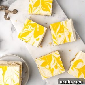 White marble surface with several squares of passion fruit cheesecake. Top view.