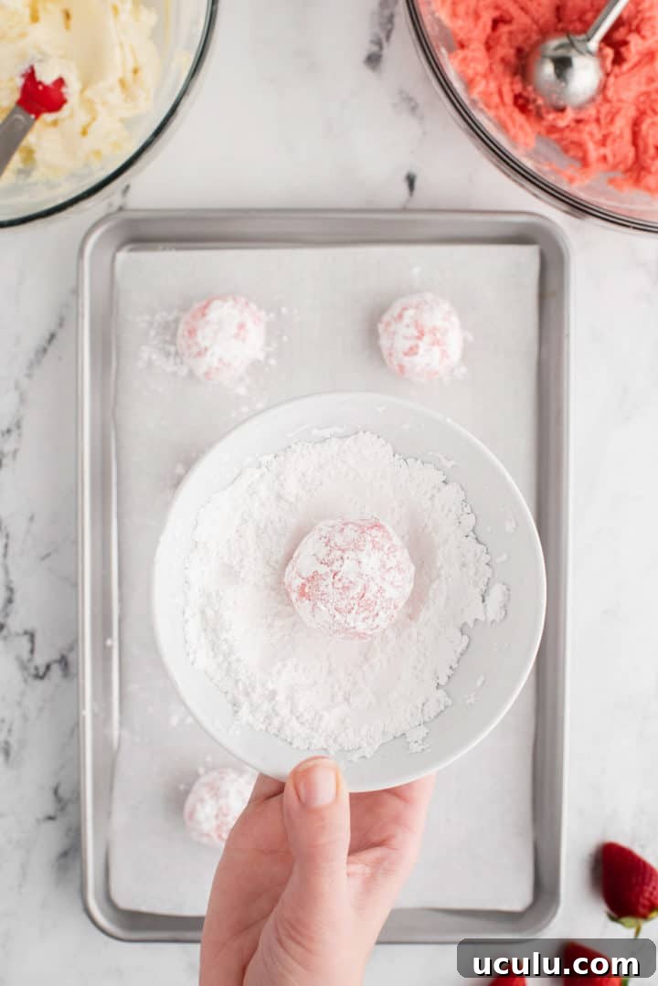 Cookie dough ball in a bowl of powdered sugar.