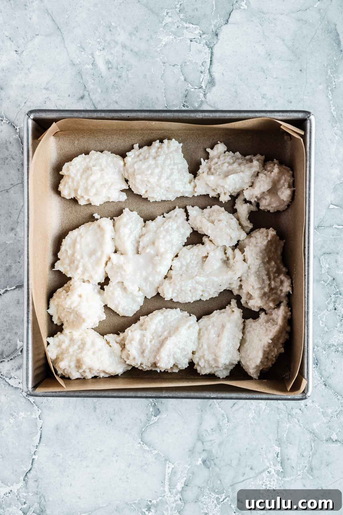 The white layer of coconut ice candy in a square pan.