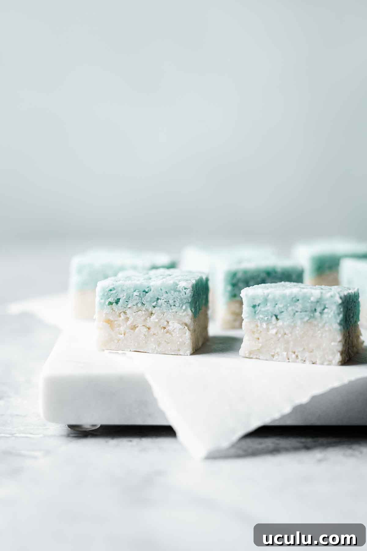 Blue and white layered candy squares on a marble tray.