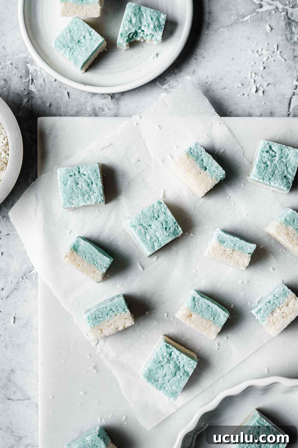 Squares of blue and white candy on a white marble tray.