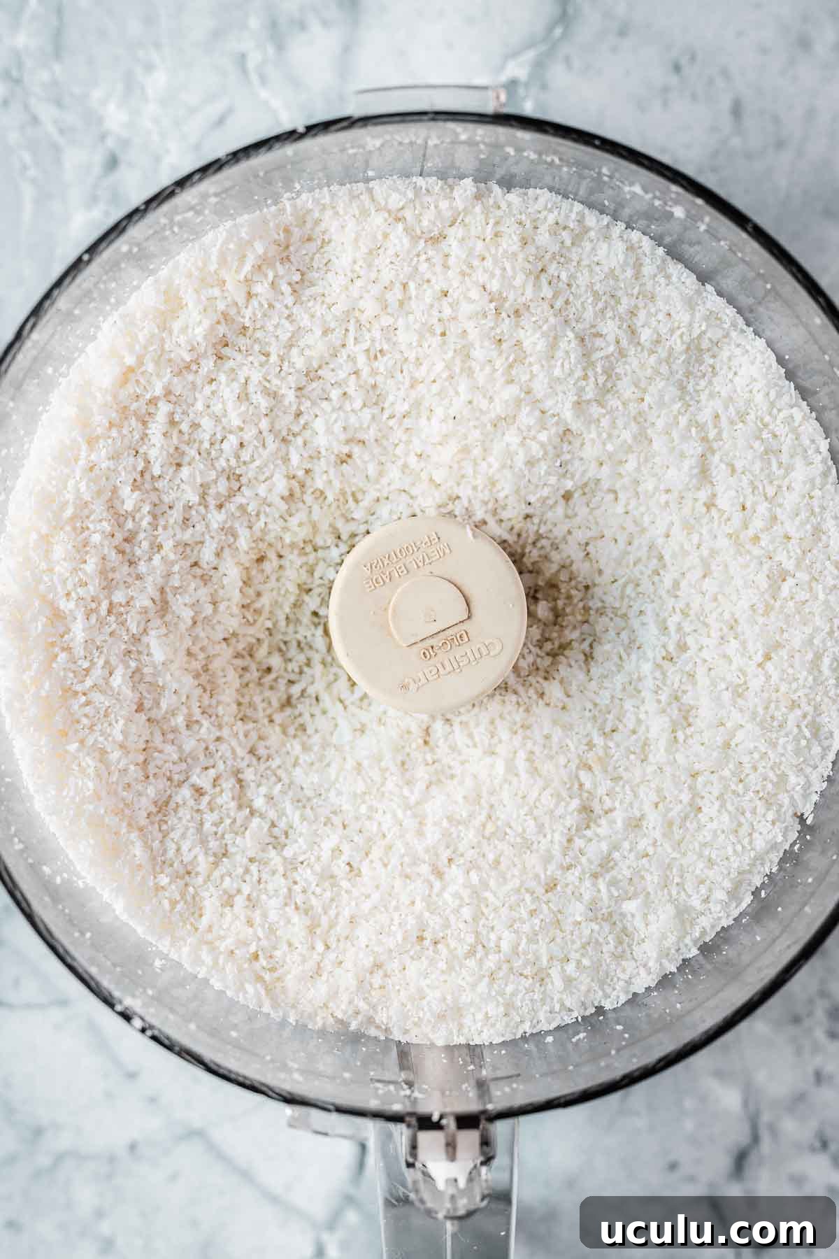 Finely shredded coconut in a food processor.