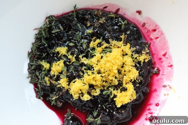 Blueberry compote, lemon zest, and thyme in a bowl for Blueberry Lemon and Thyme Ice Cream.
