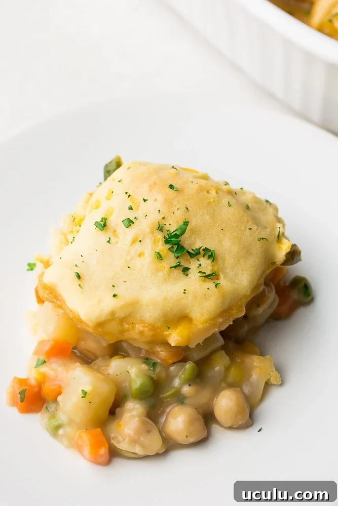 piece of biscuit topped pot pie on white plate
