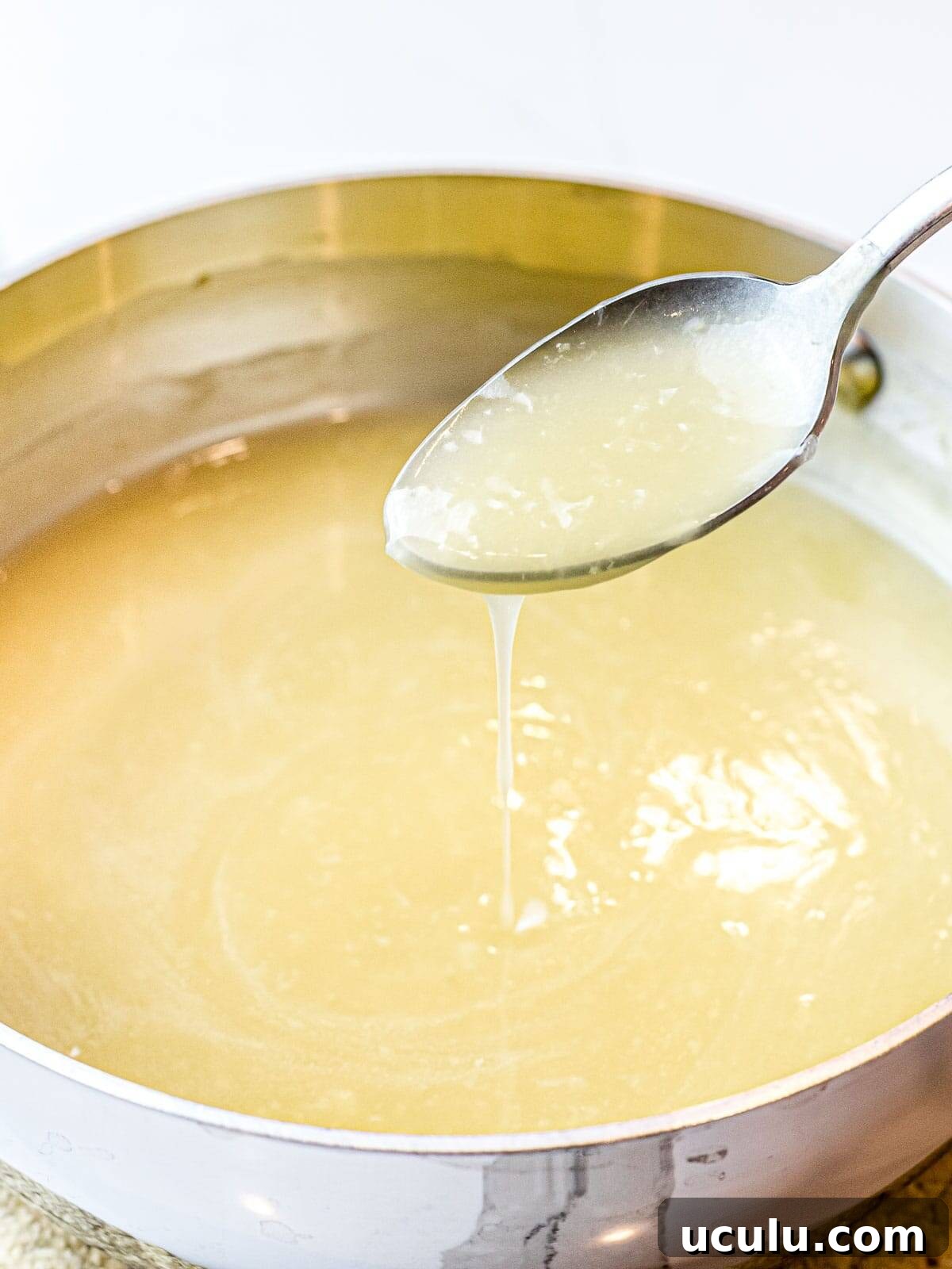 Chinese white sauce poured off a spoon into a pot