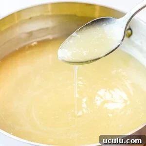 Chinese white sauce poured off a spoon into a pot