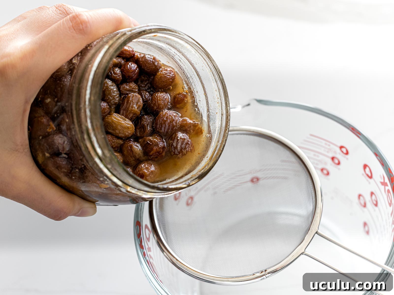 raisin yeast water being poured into a strainer