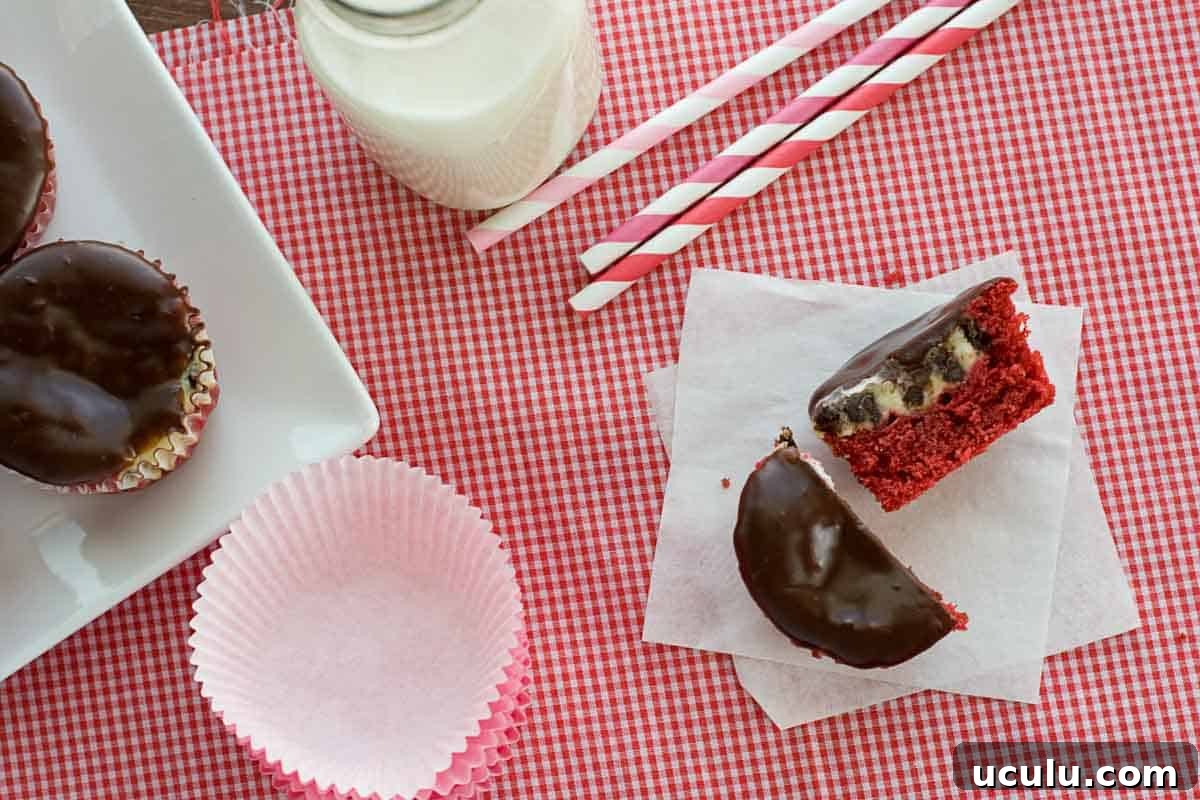 A red velvet cheesecake cupcake cut in half, with more on the side.