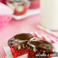 Red Velvet Cheesecake Cupcake cut in half to show cheesecake and chocolate chip center.