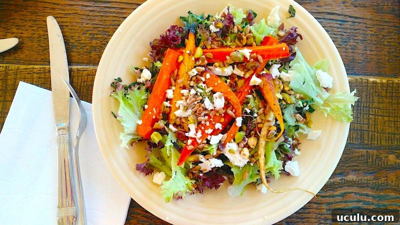 Marie's Farm Salad with Roasted Carrots and homemade citrus dressing on a plate with silverware