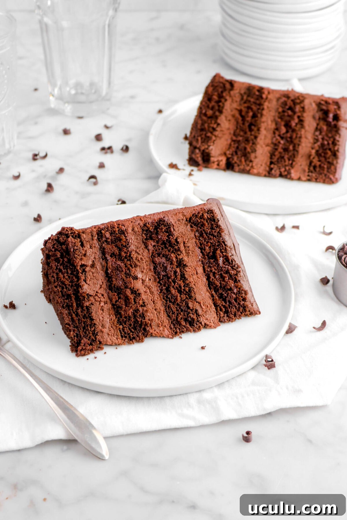 two slices of chocolate cake on white plates