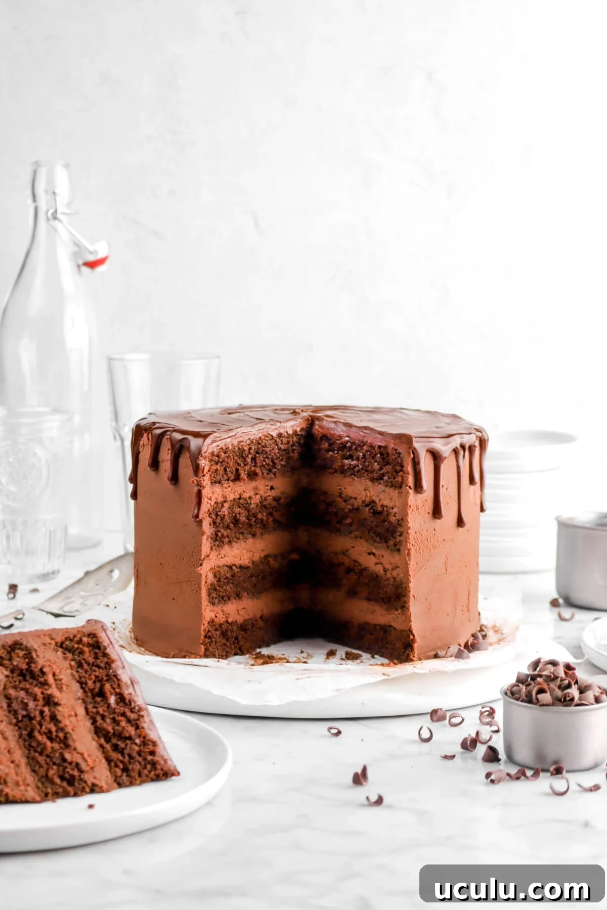 front shot of cake with two slices cut from the cake with one slice on white plate in front