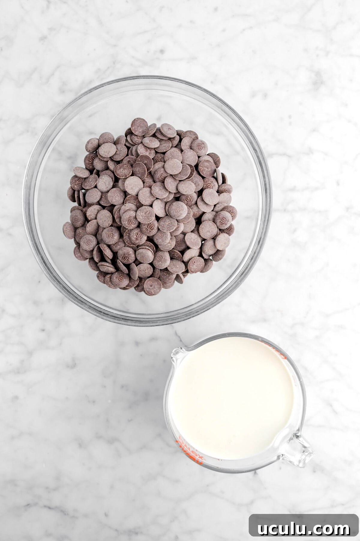chocolate chips and heavy cream on marble surface
