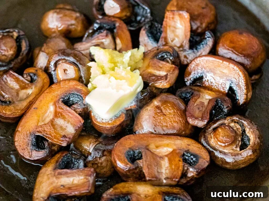 pan seared baby portobello mushrooms with minced garlic and a pad of butter added on top